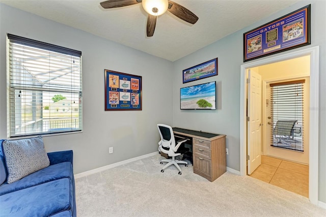 office featuring a textured ceiling, light colored carpet, and ceiling fan