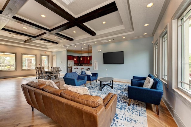 living room with beam ceiling, light wood-type flooring, crown molding, and coffered ceiling