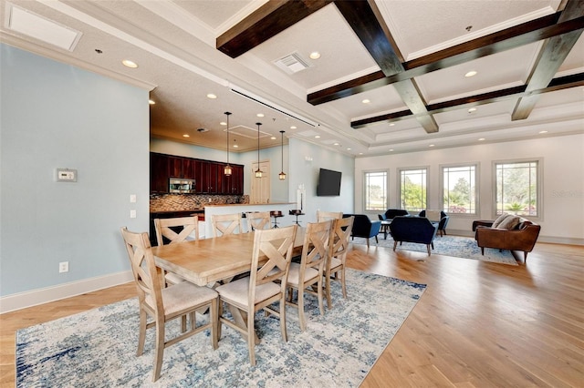 dining room with beam ceiling, light hardwood / wood-style floors, ornamental molding, and coffered ceiling