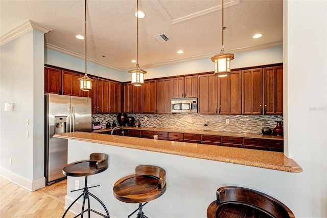 kitchen with stainless steel appliances, light stone countertops, tasteful backsplash, a kitchen bar, and pendant lighting