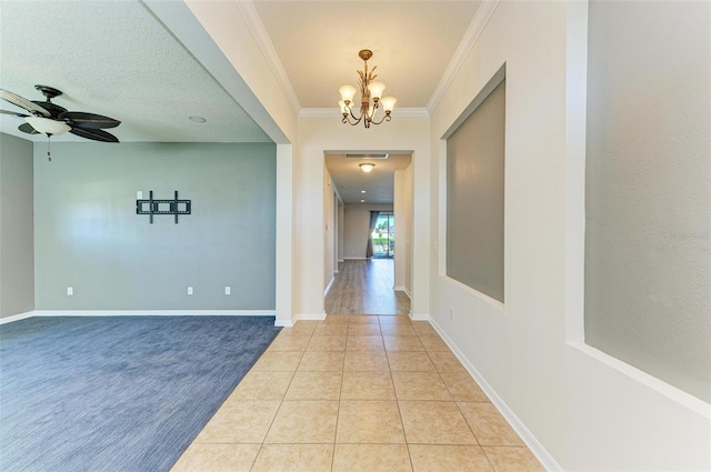 hallway featuring crown molding, light tile patterned flooring, a textured ceiling, and a notable chandelier