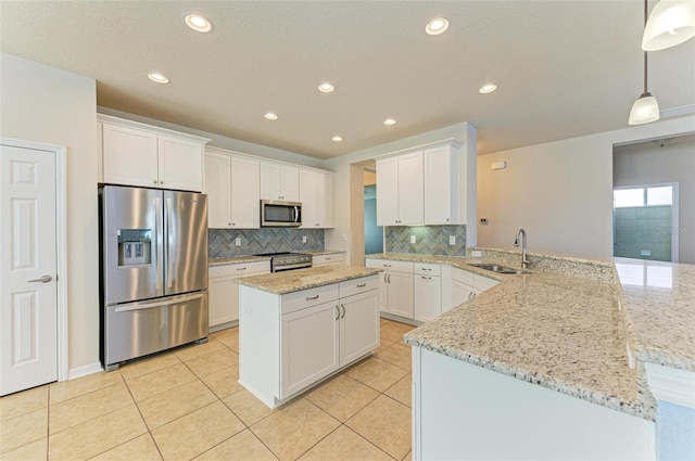 kitchen featuring kitchen peninsula, appliances with stainless steel finishes, sink, decorative light fixtures, and white cabinetry