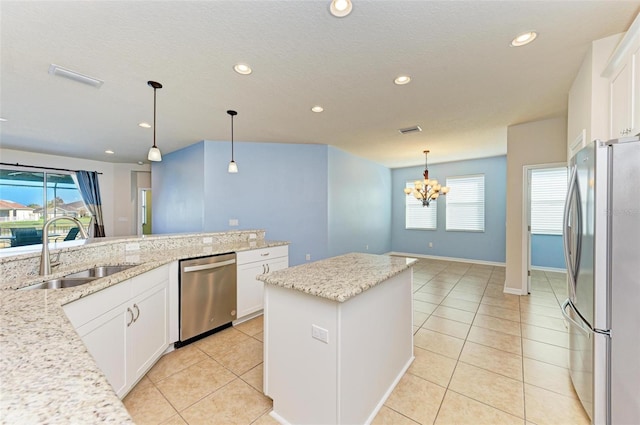 kitchen with light stone countertops, sink, white cabinets, and stainless steel appliances