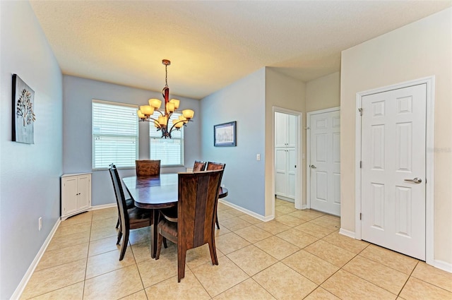 dining area featuring light tile patterned flooring, a textured ceiling, and an inviting chandelier