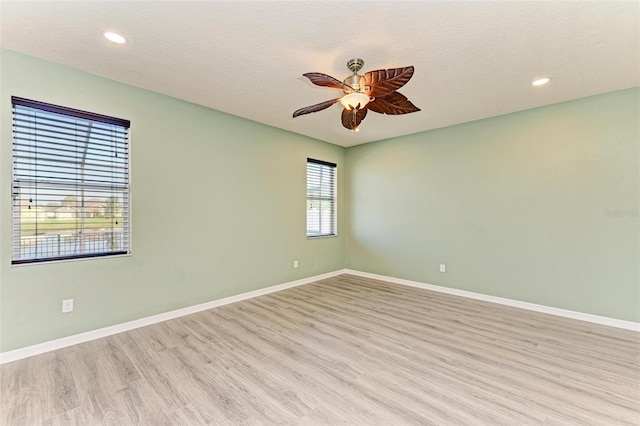 unfurnished room with ceiling fan, light hardwood / wood-style flooring, and a textured ceiling