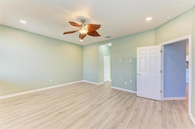 empty room with ceiling fan and light hardwood / wood-style flooring