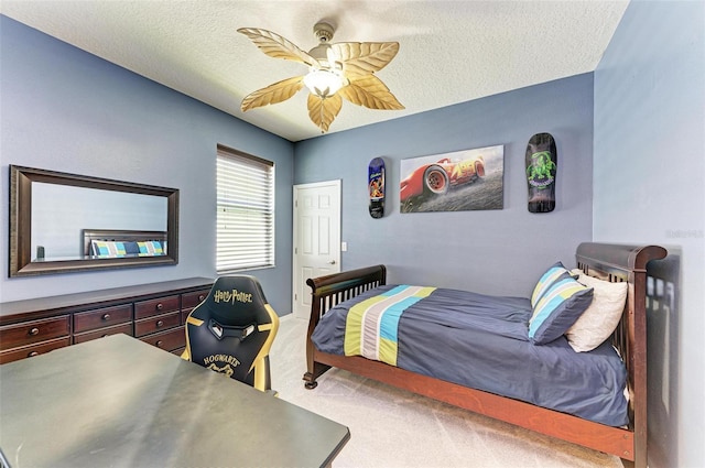 bedroom with ceiling fan, carpet, and a textured ceiling