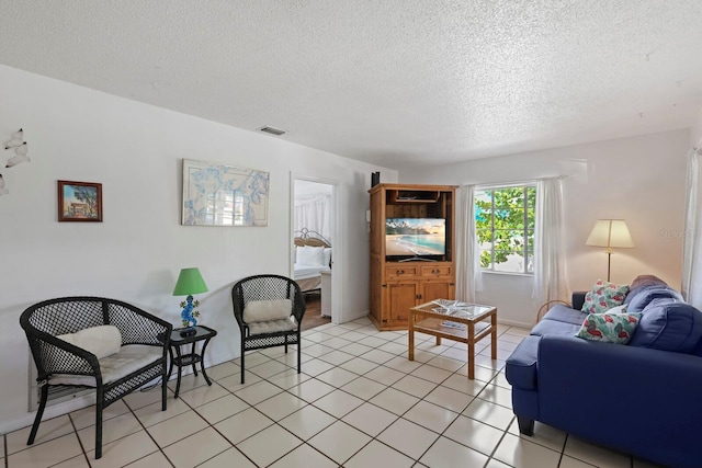 living room with light tile patterned flooring and a textured ceiling