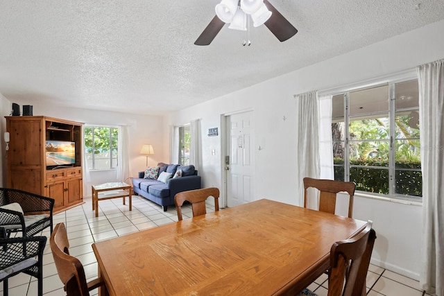 tiled dining room featuring ceiling fan and a textured ceiling