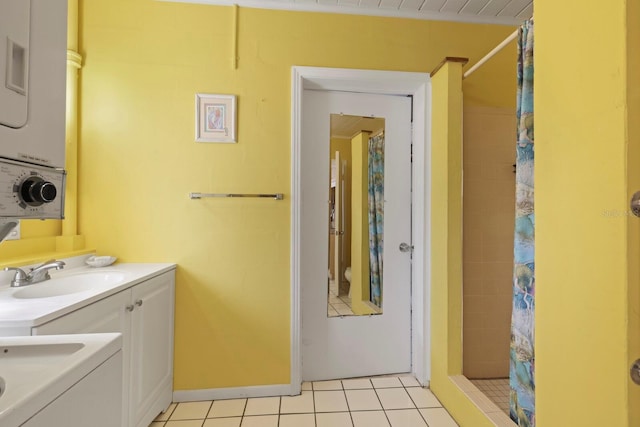 laundry room featuring sink, light tile patterned floors, and stacked washer / dryer