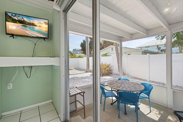 sunroom featuring beamed ceiling