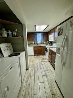 kitchen featuring washer and dryer, white appliances, light hardwood / wood-style flooring, and crown molding