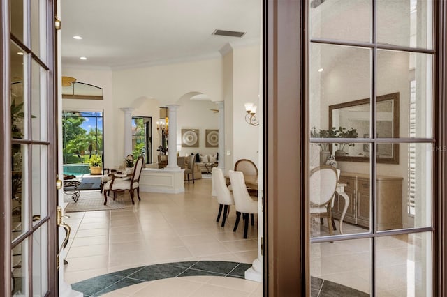 interior space with crown molding, tile patterned floors, and decorative columns