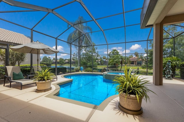 view of pool with an in ground hot tub, glass enclosure, and a patio area