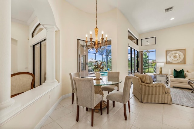 tiled dining area featuring a notable chandelier, a towering ceiling, and decorative columns