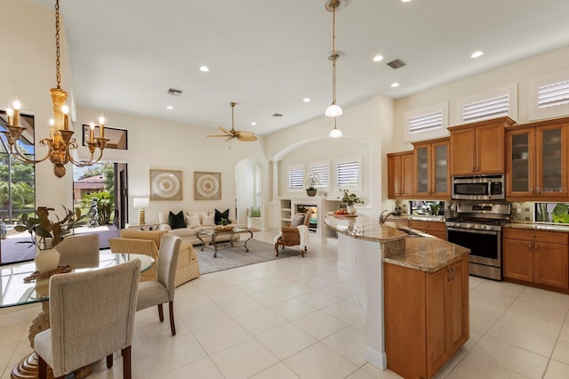 kitchen featuring sink, plenty of natural light, pendant lighting, stainless steel appliances, and light stone countertops