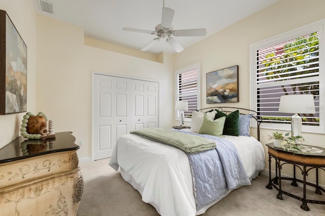 carpeted bedroom with ceiling fan and a closet