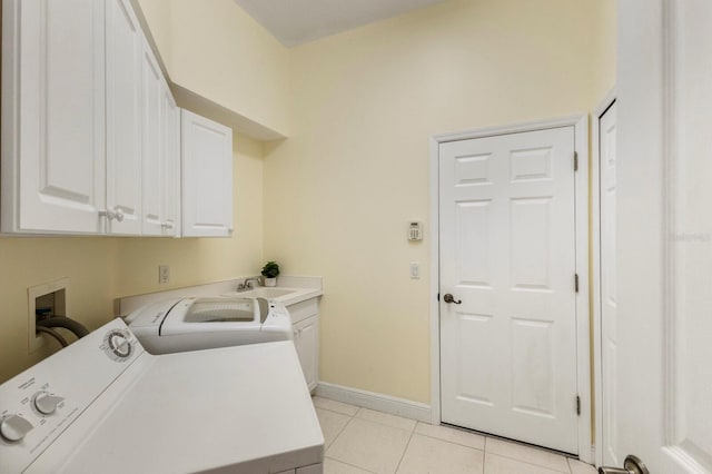 laundry room with light tile patterned floors, sink, washer and clothes dryer, and cabinets