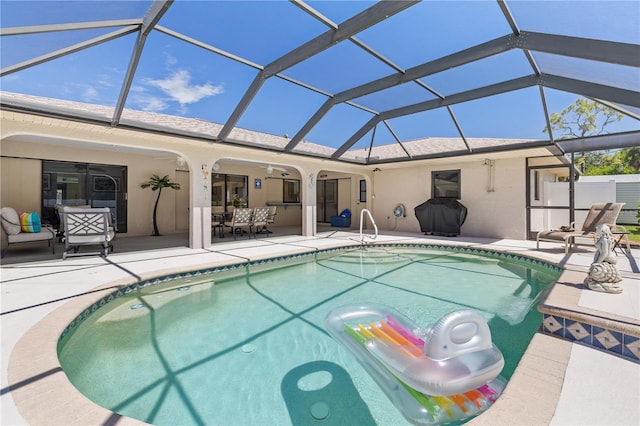 view of swimming pool featuring a patio, an outdoor hangout area, glass enclosure, and ceiling fan