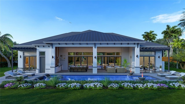 back of property with outdoor lounge area, a patio area, and a lawn