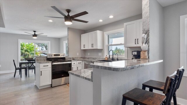 kitchen featuring white cabinetry, kitchen peninsula, and stainless steel appliances