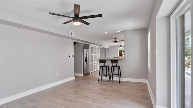 interior space with ceiling fan and light hardwood / wood-style floors