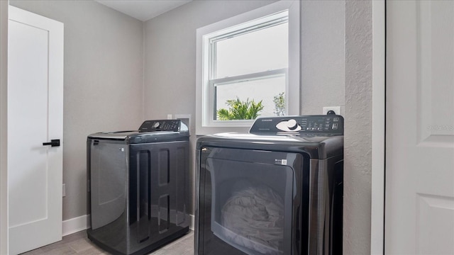 washroom featuring washing machine and dryer and light hardwood / wood-style flooring