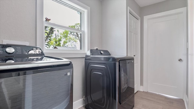 clothes washing area with washing machine and dryer