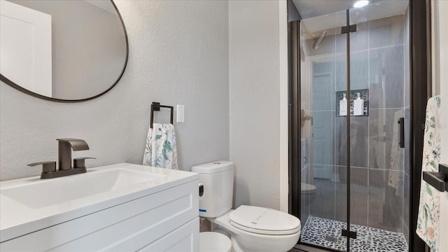 bathroom featuring vanity, an enclosed shower, and toilet