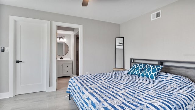 bedroom featuring ensuite bathroom, ceiling fan, and light wood-type flooring