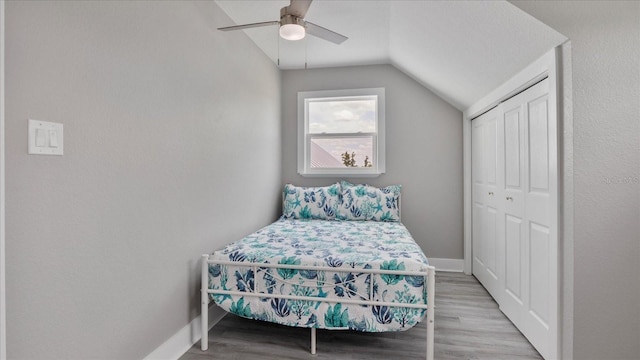 bedroom with wood-type flooring, a closet, ceiling fan, and lofted ceiling