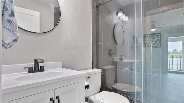 bathroom with vanity, toilet, and a shower with door