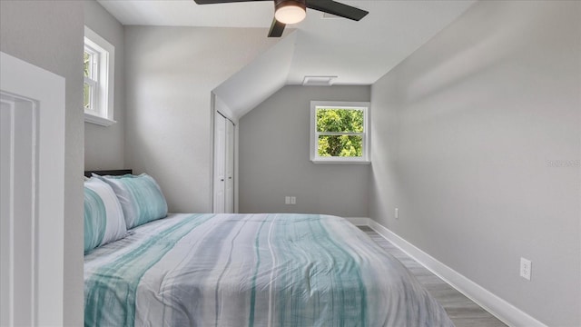 bedroom with multiple windows, ceiling fan, and lofted ceiling