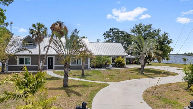 view of front of house featuring a water view and a front lawn