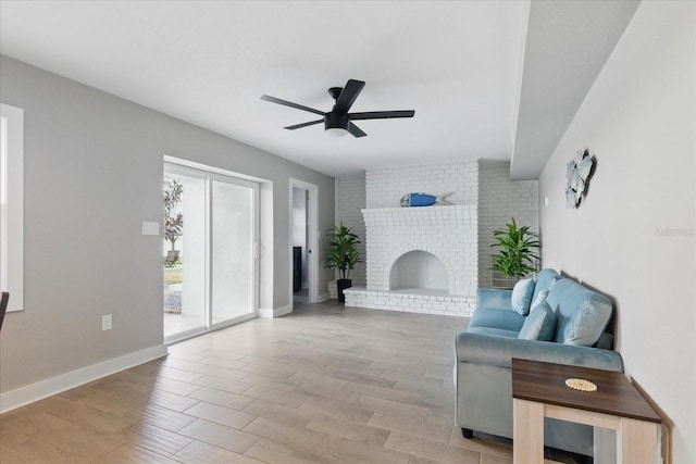 9610 SW Yacht Dr, Arcadia, FL 34269 - living room with baseboards, a ceiling fan, light wood-type flooring, and a brick fireplace