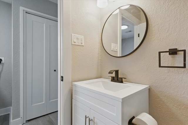 9610 SW Yacht Dr, Arcadia, FL 34269 - bathroom with vanity, a textured wall, and wood finished floors