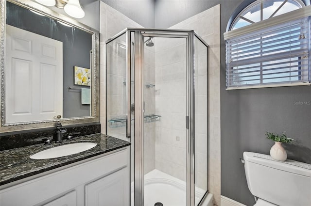 bathroom with vanity, toilet, and a shower with shower door