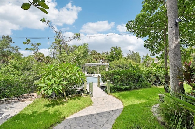 view of home's community featuring a boat dock and a yard