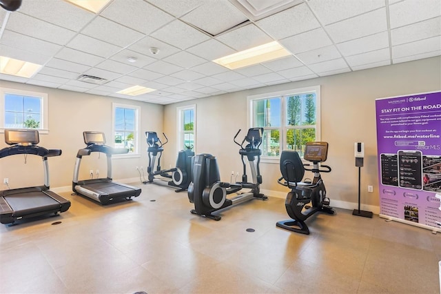 workout area with tile flooring and a drop ceiling