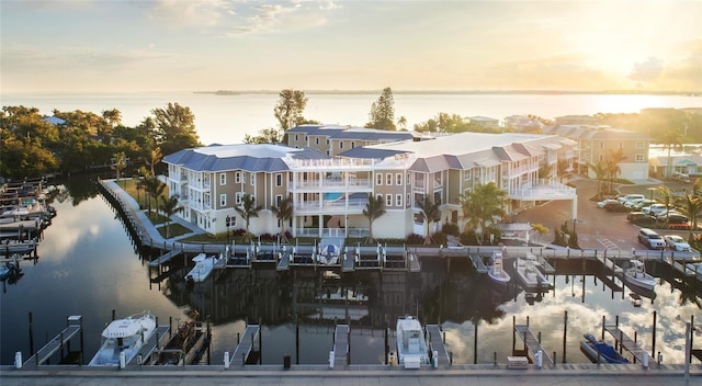 aerial view at dusk featuring a water view