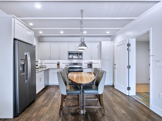 kitchen with dark hardwood / wood-style flooring, white cabinets, pendant lighting, and appliances with stainless steel finishes