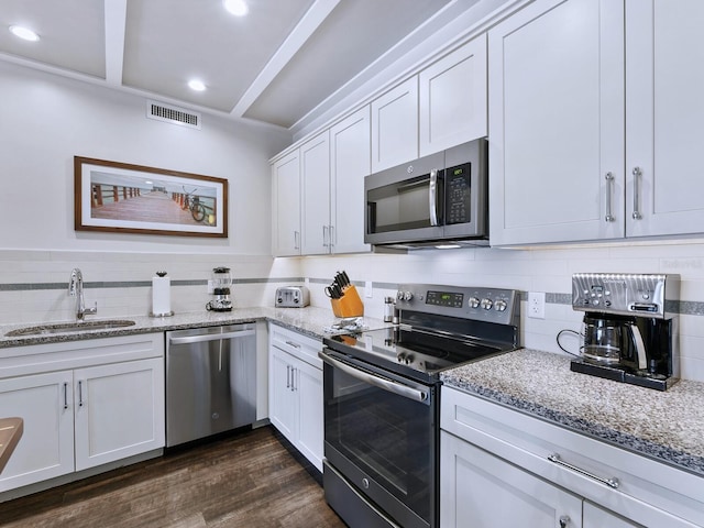 kitchen featuring dark wood-type flooring, white cabinets, sink, appliances with stainless steel finishes, and light stone counters