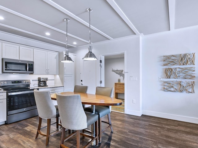 dining area featuring beam ceiling and dark wood-type flooring