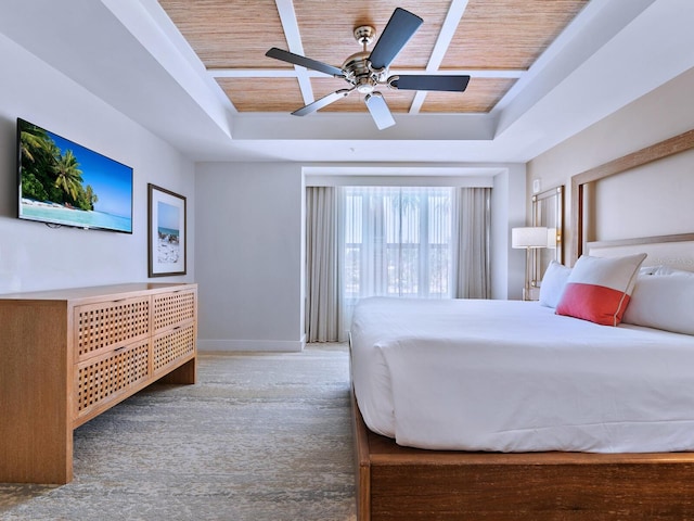 carpeted bedroom with wooden ceiling, ceiling fan, and a tray ceiling