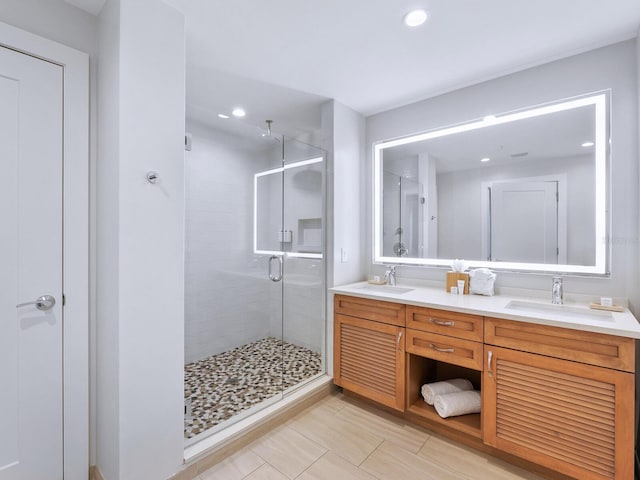 bathroom with walk in shower, dual sinks, tile flooring, and vanity with extensive cabinet space