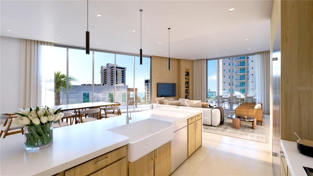 kitchen with light brown cabinets, light tile flooring, pendant lighting, sink, and floor to ceiling windows