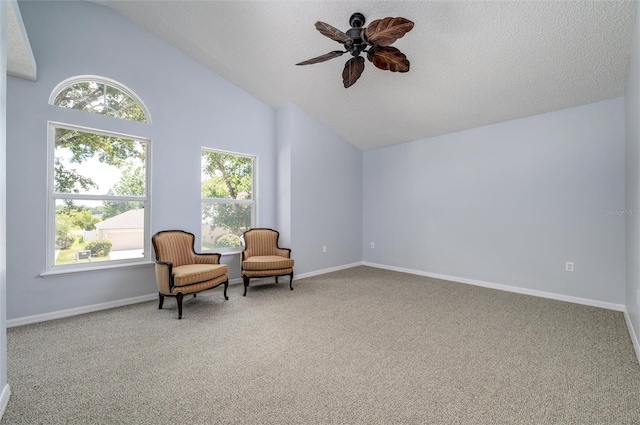 sitting room with carpet floors, a wealth of natural light, ceiling fan, and vaulted ceiling