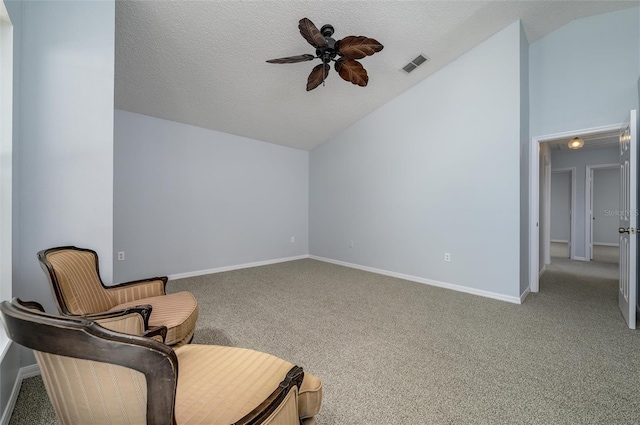 sitting room with a textured ceiling, ceiling fan, carpet flooring, and vaulted ceiling