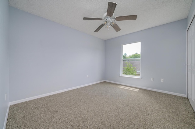 spare room featuring carpet flooring, ceiling fan, and a textured ceiling