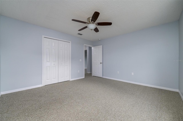 unfurnished bedroom featuring a textured ceiling, a closet, ceiling fan, and carpet floors